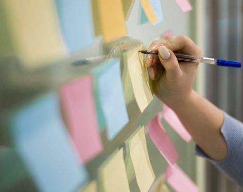 woman-writing-sticky-notes-office-window